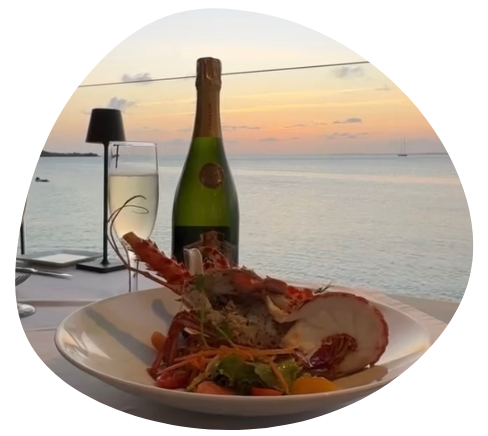 Vue sur la mer depuis un restaurant, avec une bouteille de champagne en premier plan